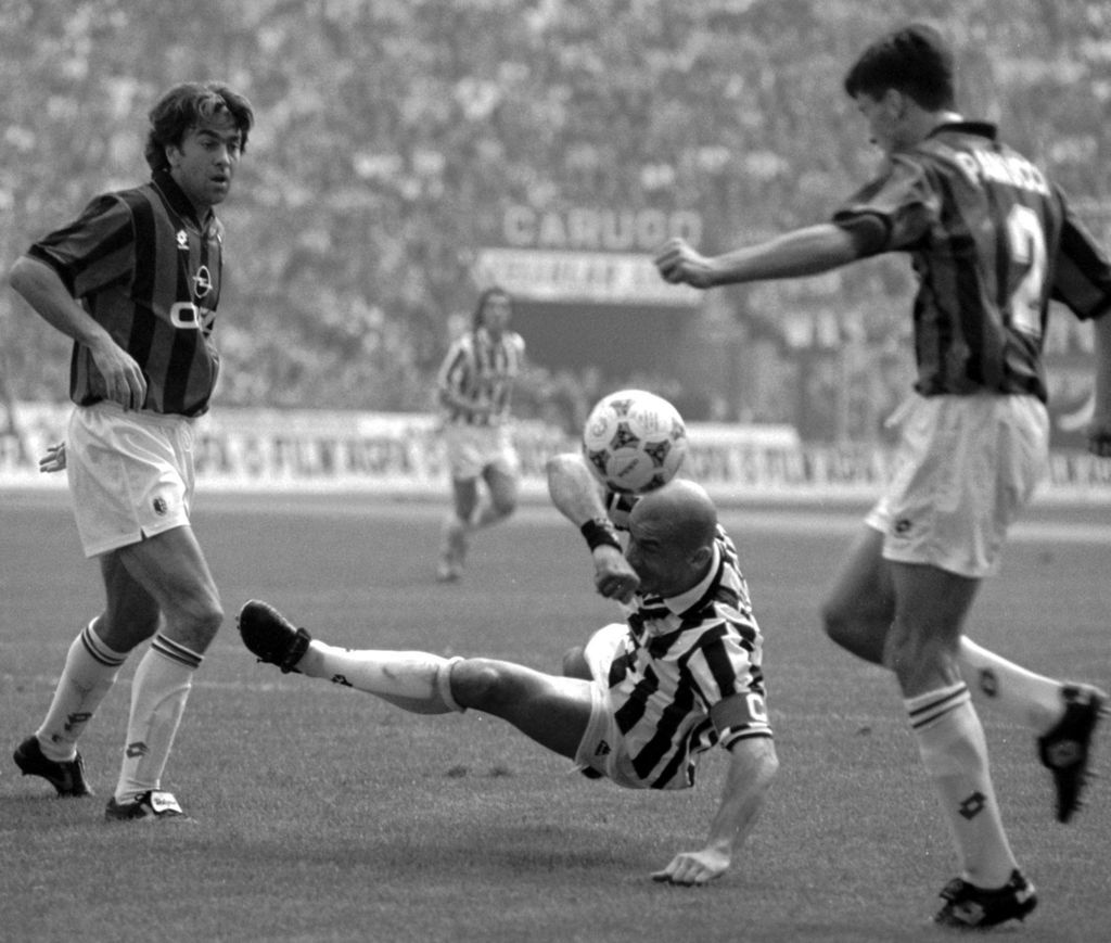 Penyerang Juventus Gianluca Vialli (tengah) menyundul bola di tengah kepungan dua pemain AC Milan, Alessandro Costacurta (kiri) dan Christian Panucci, pada laga Liga Italia Serie A di Stadion San Siro, Milan, Italia, 15 Oktober 1995. 