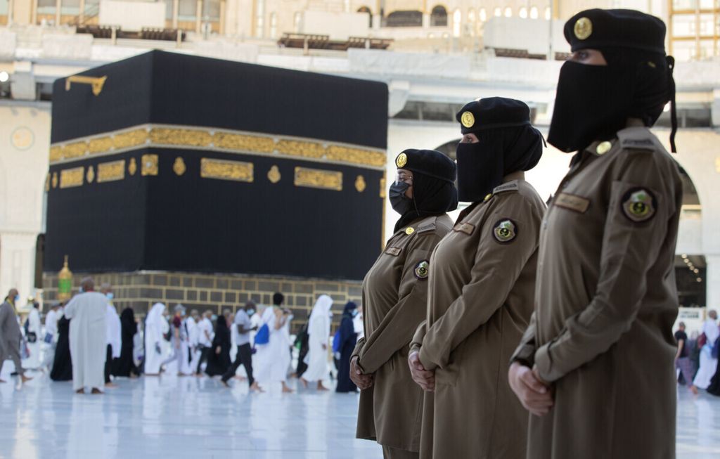 Saudi police women, who are recently deployed to the service, from right to left, Samar, Alaa, and Bashair, stand alert in front of the Kaaba, the cubic building at the Grand Mosque, during the annual hajj pilgrimage, in the Saudi Arabia's holy city of Mecca, Tuesday, July 20, 2021. 