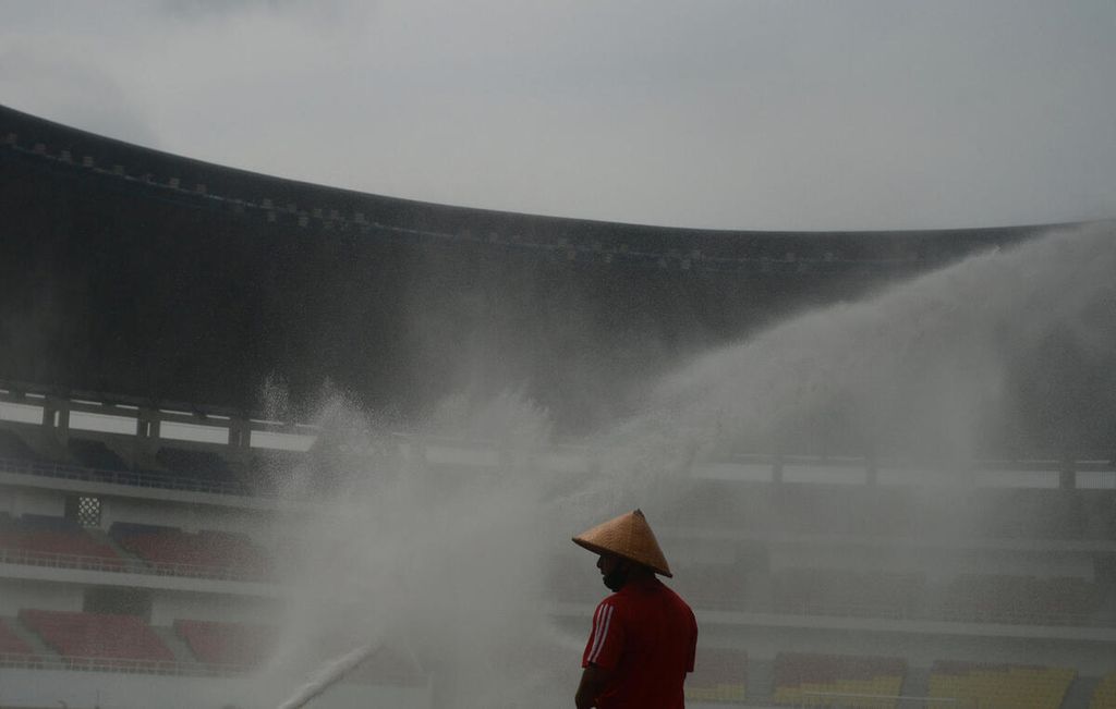 Petugas mengawasi prores penyiraman rumput lapangan sepak bola di Stadion Jati Diri, Kota Semarang, Jawa Tengah, Selasa (18/1/2022). 