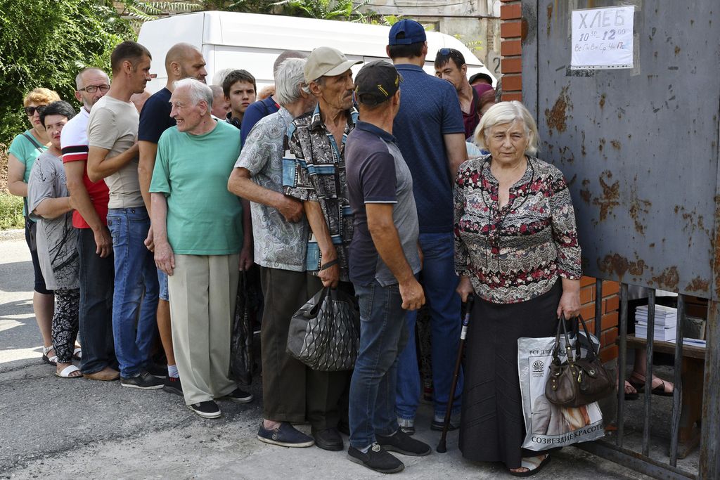 Warga mengantre untuk menerima pembagian roti di pos distribusi bantuan kemanusiaan di Zaprorizhia, Ukraina, 4 Agustus 2022. 