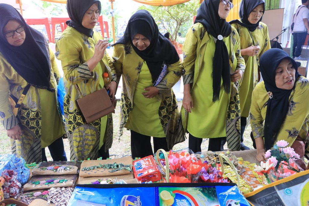 Para pengunjung melihat hasil kreasi daur ulang sampah plastik yang dibuat Ainun Saniah pada pameran pertemuan bank sampah di Kota Medan, Sumatera Utara, Selasa (24/1/2023). 