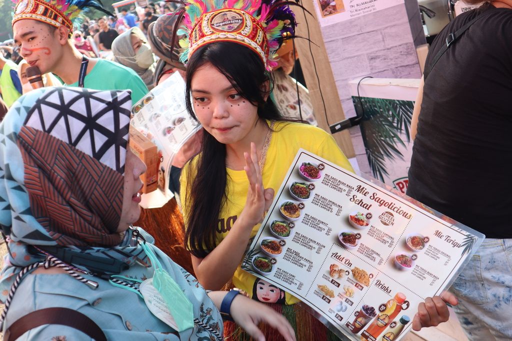 Seorang pramuniaga tengah menawarkan menu makanan kepada pengunjung Jakarta Fair Kemayoran, Jakarta Pusat, Sabtu (18/6/2022).