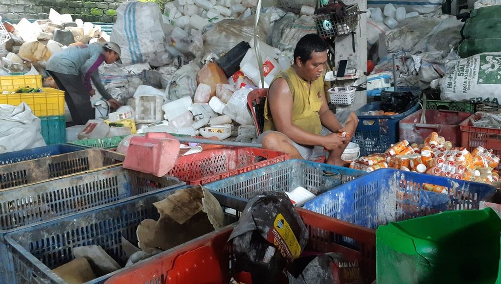 Pekerja memilah dan memisahkan sampah plastik kemasan di sebuah tempat pengumpulan sampah plastik di Kota Denpasar, Bali, Jumat (10/2/2023). Sejumlah jenis sampah plastik kemasan masih memiliki nilai ekonomi dan dapat didaur ulang.