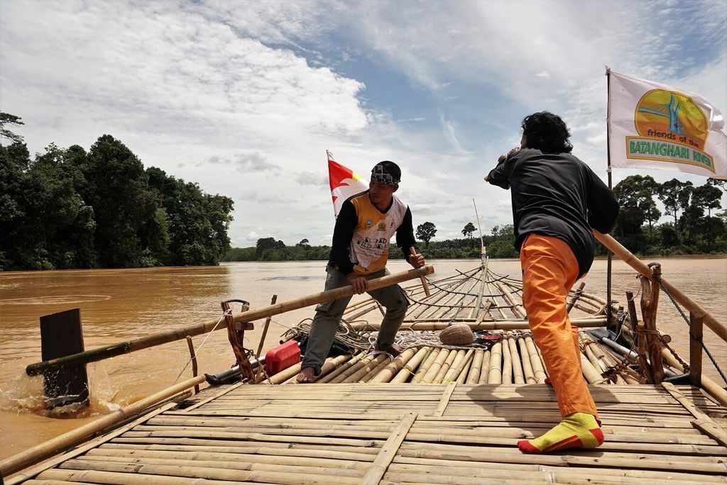 Tim Milir Berakit Sungai Batanghari mengayuhkan batang bambu agar rakit dapat melaju lebih cepat menuju hilir, Kamis (17/11/2022). Tanpa menggunakan bantuan mesin, rakit melaju pelan-pelan. Tim diperkirakan mencapai hilir dalam lima hari perjalanan.