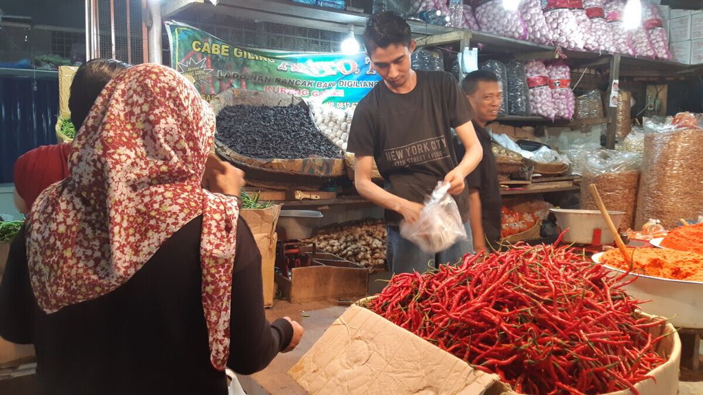 Pedagang mengambilkan cabai merah pesanan pembeli di Blok II, Pasar Raya Padang, Sumatera Barat, Selasa (27/8/2019). 