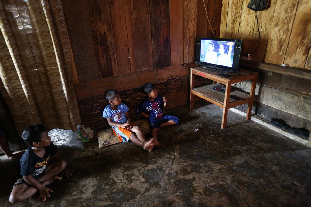 Anak-anak menonton televisi di salah satu rumah warga di Kampung Lale, Desa Wewo, Kecamatan Satar Mese, Kabupaten Manggarai, Nusa Tenggara Timur, Selasa (5/10/2021). Listrik di desa tersebbut menyala sejak November 2011 bersamaan dengan beroperasinya PLTP Ulumbu.