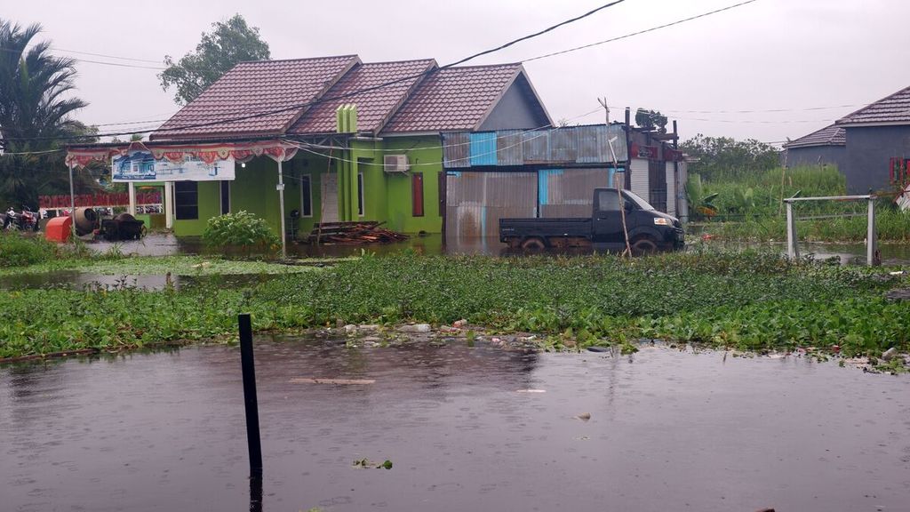 Banjir menggenangi salah satu kompleks perumahan warga di Desa Sungai Lulut, Kecamatan Banjarmasin Timur, Kota Banjarmasin, Kalimantan Selatan, Jumat (15/1/2021). Banjir terjadi sejak Kamis akibat tingginya intensitas curah hujan.