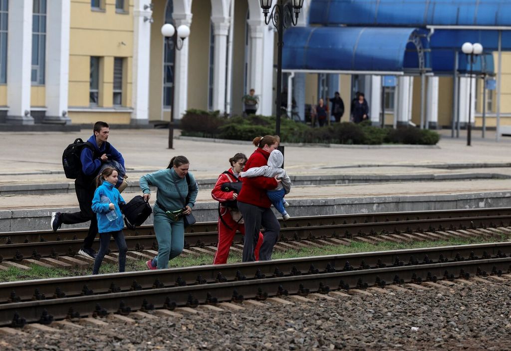 Warga berlarian menuju peron saat akan naik kereta di stasiun pusat Slovyansk di wilayah Donbas, 12 April 2022, di tengah invasi Rusia atas Ukraina. Warga sipil diminta mengungsi untuk mengantisipasi perebutan wilayah oleh pasukan Rusia.  