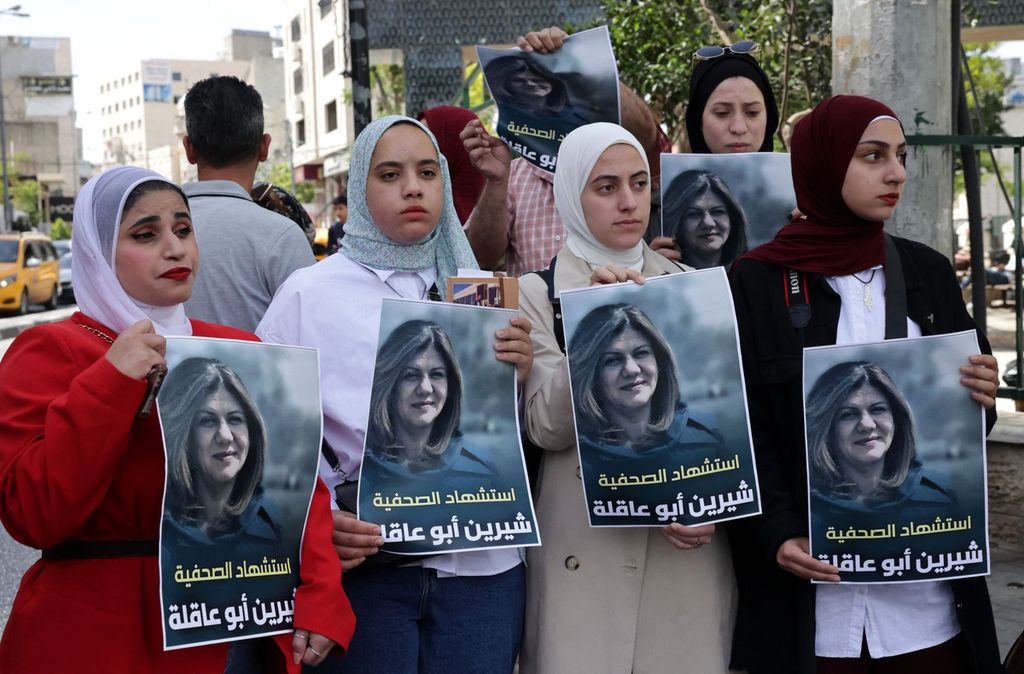 Warga Palestina memegang poster bergambar jurnalis Al Jazeera, Shireen Abu Akleh, yang ditembak mati pasukan Israel saat meliput serangan di kamp pengungsi Jenin 11 Mei 2022 di kota Hebron.