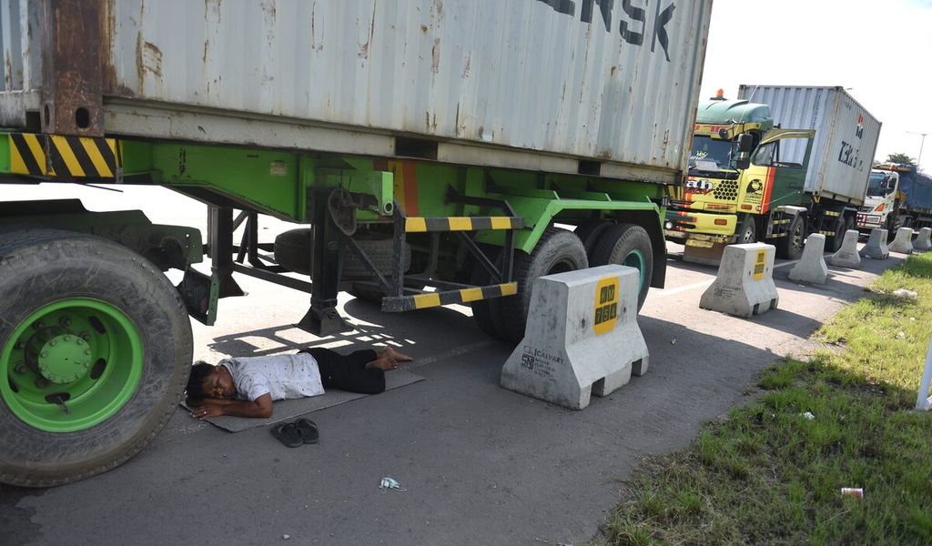 Sopir truk Yabaniadama tertidur di bawah truknya saat antre untuk mendapatkan solar di SPBU Rest Area Km 754 ruas Jalan Tol Surabaya-Gempol, Kabupaten Sidoarjo, Jawa Timur, Selasa (5/4/2022).  