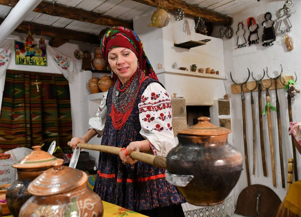 Arsip foto yang diambil pada 26 November 2020 menunjukkan Olenka Shcherban, etnolog dan sejarawan Ukraina, yang mempelajari <i>borshch </i>dan memiliki 365 resep unik <i>borscht</i> dari seluruh penjuru Ukraina. Mengenakan busana tradisional, Shcherban tengah memasak <i>borscht</i> di Opishnya, wilayah Poltava. 