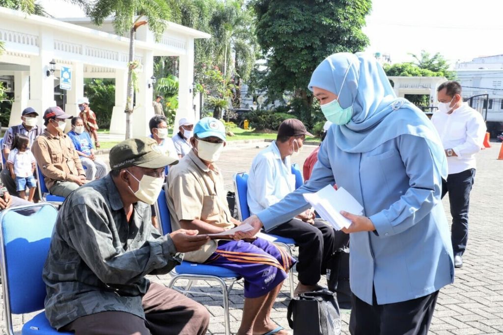 Gubernur Jawa Timur Khofifah Indar Parawansa membagikan tunjangan hari raya kepada masyarakat berpenghasilan rendah terdampak Covid-19, Senin (10/5/2021), di Surabaya, Jatim.