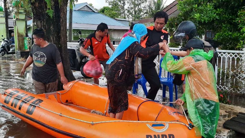 Petugas mengevakuasi korban banjir di Kabupaten Paser, Kalimantan Timur, Jumat (22/4/2022). Sedikitnya 1.700 jiwa terdampak banjir dengan genangan 30 sentimeter sampai 1 meter.