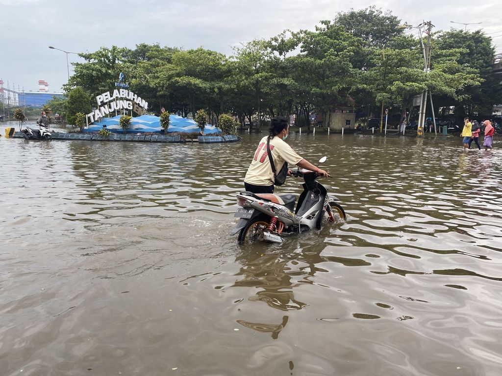 Pekerja mendorong kendaraannya keluar dari kawasan Pelabuhan Tanjung Emas, Kota Semarang, Jawa Tengah, Rabu (26/5/2022). Ribuan kendaraan para pekerja di kawasan itu terendam banjir rob selama beberapa hari lantaran ditinggal pemiliknya menyelamatkan diri saat tanggul laut di kawasan itu jebol pada Senin (23/5/2022). Kendaraan-kendaraan itu langsung dibawa ke bengkel untuk diperbaiki setelah terendam banjir rob setinggi 1,5 meter.