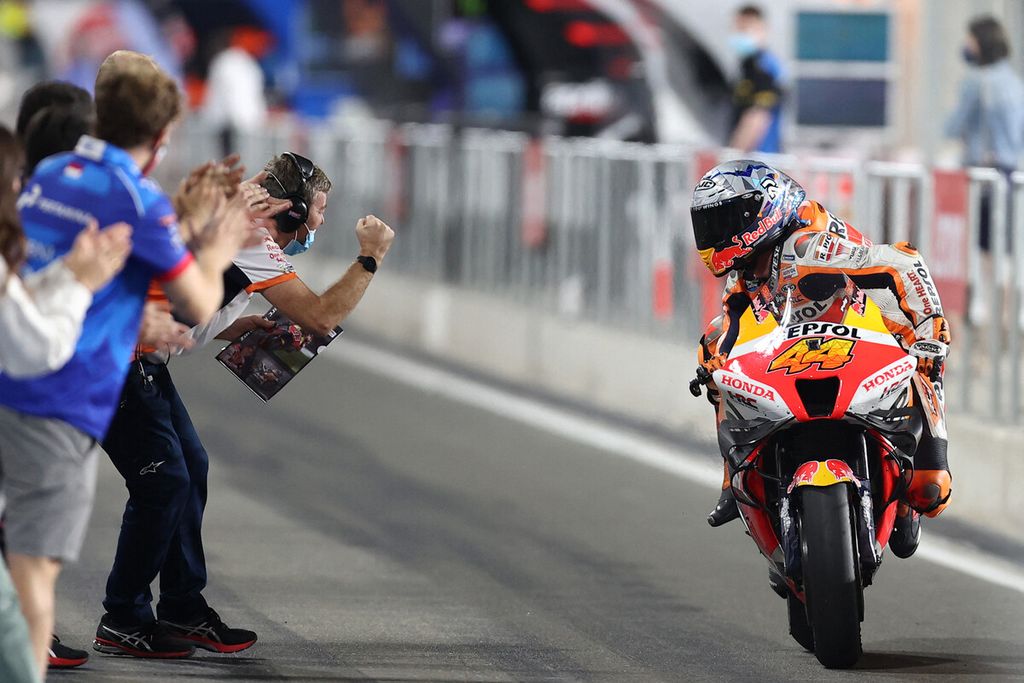 Pebalap Spanyol dari tim Repsol Honda, Pol Espargaro, merayakan posisi kedua bersama timnya saat melalui lintasan <i>paddock </i>setelah melakoni putaran pertama musim MotoGP 2022 di Sirkuit Losail, Qatar, Minggu (6/3/2022). 