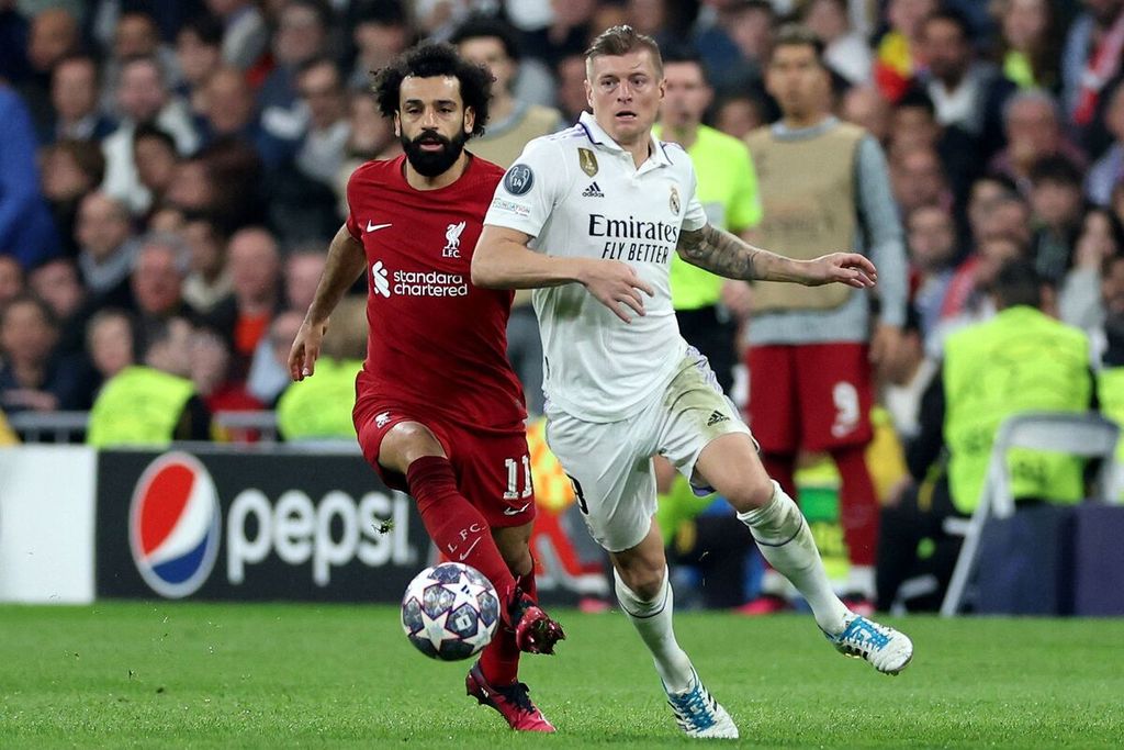 Pemain Liverpool Mohamed Salah (kiri) berebut ola dengan Real Madrid Toni Kroos pada laga kedua babak 16 besar Liga Champions di Stadion Santiago Bernabeu, Madrid, Spanyol, Kamis (16/3/2023) dini hari WIB. Madrid menang 1-0 dan lolos ke perempat final dengan agregat 6-2. 