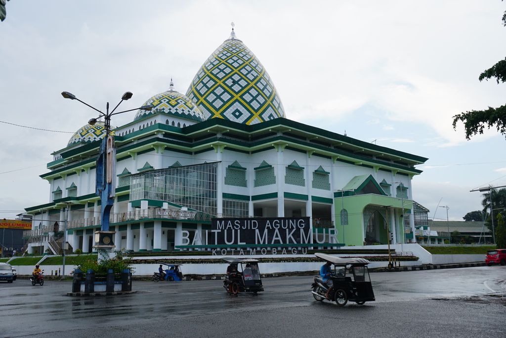 Beberapa bendi motor atau bentor melintas di muka Masjid Agung Baitul Makmur, Kotamobagu, Sulawesi Utara, jelang waktu berbuka puasa, Selasa (4/5/2021). Masjid itu selesai dibangun pada 2020 dengan dana Rp 2,4 miliar.