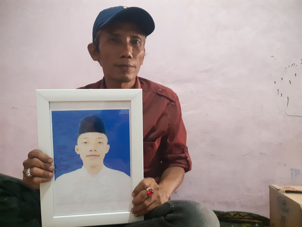 Rusdi (47) memegang foto anak sulungnya, Albar Mahdi (17), yang meninggal dunia diduga akibat dianiaya oleh seniornya di Pondok Modern Darussalam Gontor, Ponorogo Jawa Timur, Jumat (9/9/2022). Rusdi meminta keadilan agar pelaku ditindak sesuai dengan hukum yang berlaku.