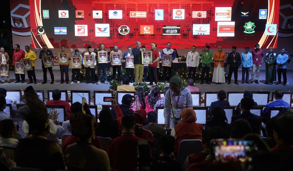 Ketua KPU Hasyim Asy’ari ketika menyerahkan plakat nomor urut kepada perwakilan pimpinan partai politik peserta Pemilu 2024 dalam acara Pengundian dan Penetapan Nomor Partai Politik Peserta Pemilihan Umum 2024 di halaman Kantor Komisi Pemilihan Umum (KPU), Jakarta, Rabu (14/12/2022). 