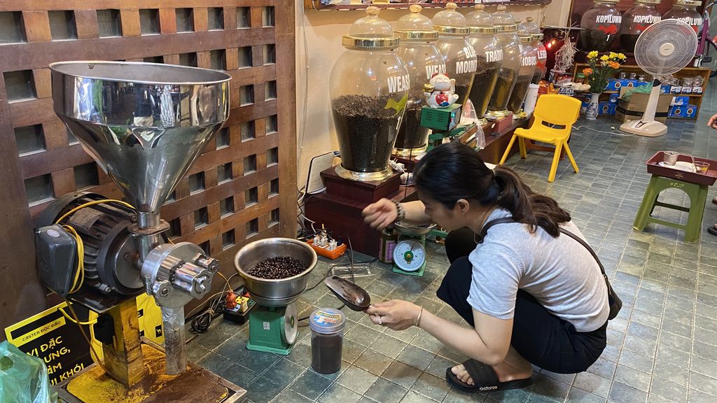 Thuy Ha Dang (45), pemilik Coffee Viet Nam Long Thabh, menggiling biji kopi yang sudah disangrai agar menjadi bubuk untuk disajikan dengan teknik seduh <i>vietnam</i><i>drip</i>, Sabtu (14/4/2022). 