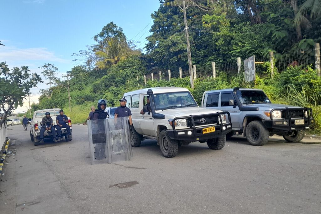 Polisi memblokade jalan di Honiara, Kepulauan Solomon, Jumat (26/11/2021). Kerusuhan sudah mereda, tetapi pemerintah belum mau membahas penyebabnya, yaitu kegelisahan masyarakat mengenai kedekatan Kepulauan Solomon dengan China.    