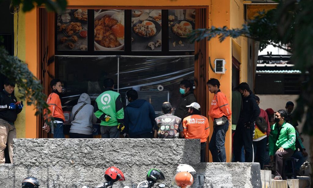 Pengemudi layanan ojek daring menunggu mengambil makanan pesanan pelanggan di salah satu gerai makanan di Setiabudi, Jakarta Selatan, Selasa (9/11/2021). Penggunaan layanan pesan antar makanan oleh masyarakat meningkat selama pandemi. Pascapandemi pertumbuhan bisnis pesan antar makanan di Indonesia diperkirakan dapat mencapai 50 persen.
