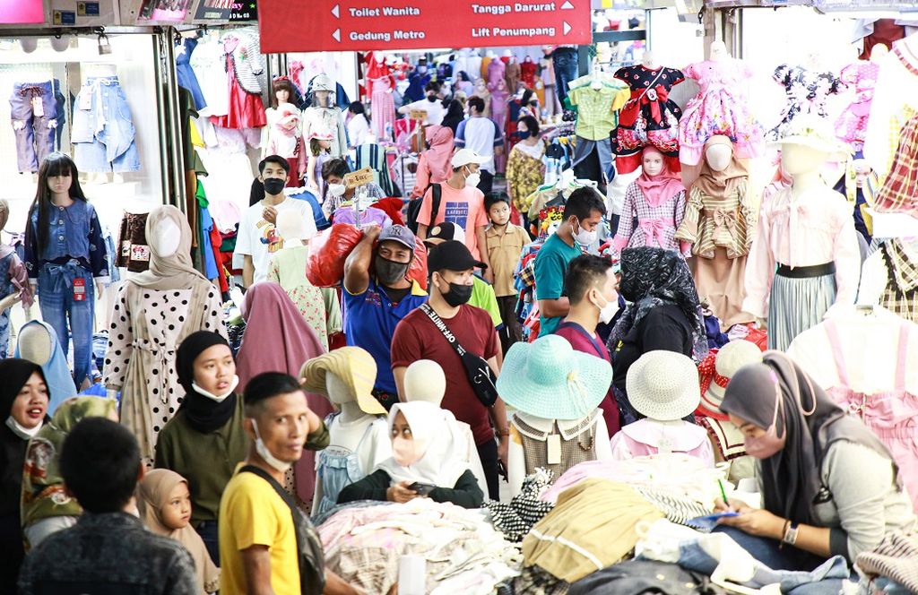 Suasana salah satu lorong di Blok B Pasar Tanah Abang, Jakarta Pusat, yang ramai pengunjung, Rabu (20/4/2022). Belanja lebaran masyarakat di pasar tekstil terbesar ini mulai meningkat seiring dengan pencairan tunjangan hari raya (THR) pegawai negeri tahun ini.