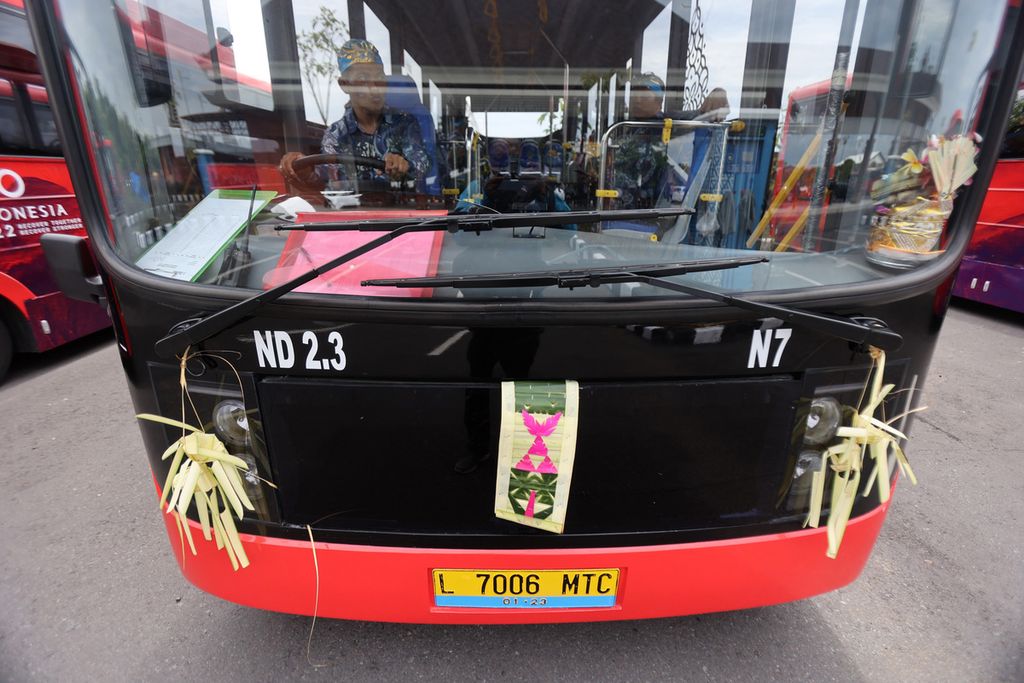 Sampian gantung, or coconut leaves-plaited hangings, are installed on the front of an electric bus, said as a repellent against bad fortune. 