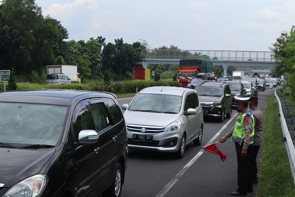 Polisi mengarahkan pengendara agar tidak masuk Rest Area 207A di ruas Tol Palimanan-Kanci, Cirebon, Jawa Barat, Kamis (28/4/2022). Pengelola tol dan kepolisian kembali menerapkan sistem buka tutup area istirahat untuk mengurai kepadatan. 
