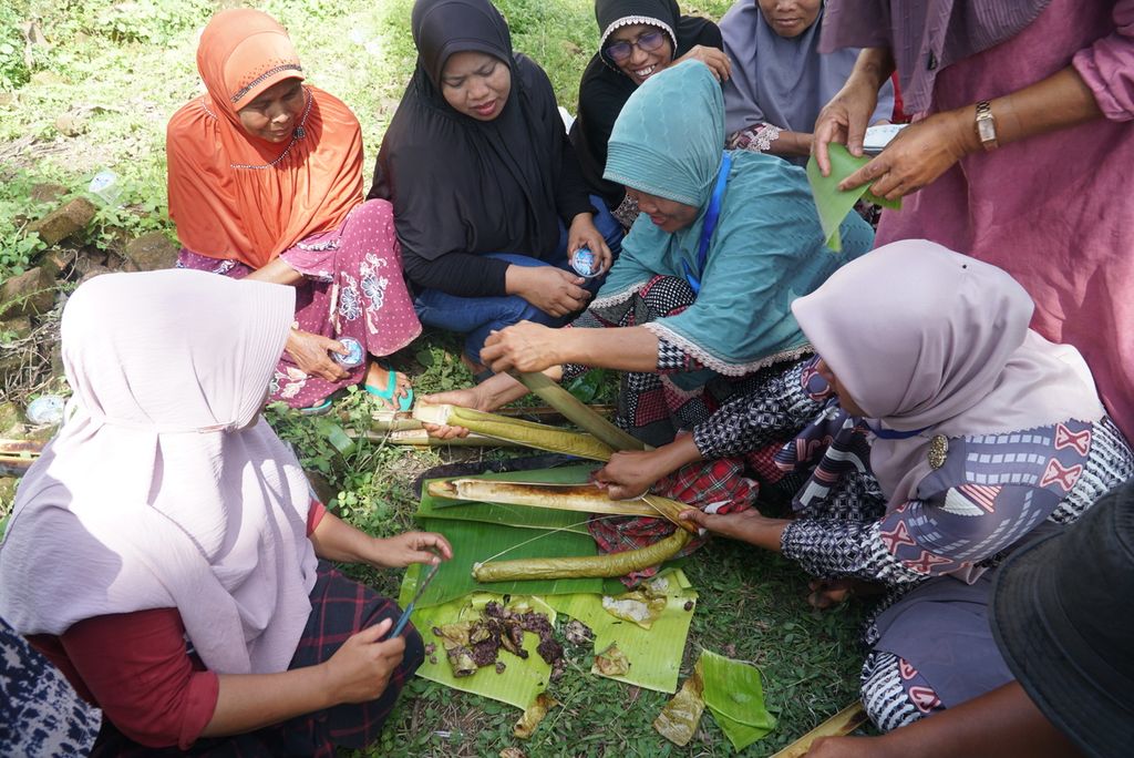 Warga membuka tabung lamang (lemang) yang sudah matang dalam acara "Malamang Sakampuang" di Kelurahan Aie Pacah, Kecamatan Koto Tangah, Kota Padang, Sumatera Barat, Sabtu (31/12/2022).
