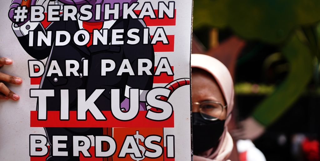 Seorang aktivis yang tergabung dalam Gerakan #BersihkanIndonesia, Perempuan Indonesia Anti-Korupsi, BEM SI, dan beberapa perwakilan organisasi lain menggelar aksi di depan Gedung Merah Putih Komisi Pemberantasan Korupsi, Jakarta, Selasa (9/11/2021). 
