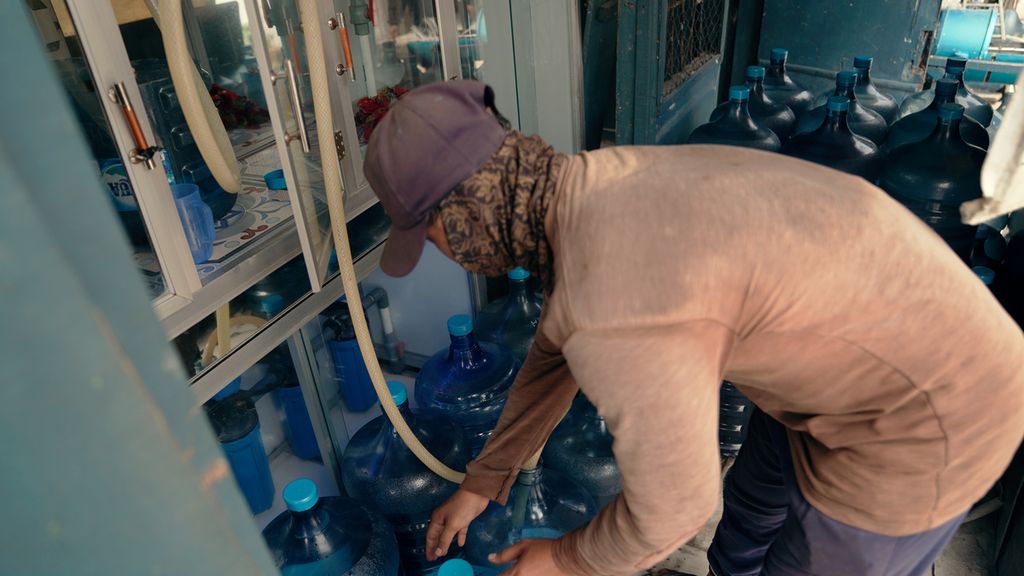 Pekerja mengisi ulang air kemasan galon berbahan polikarbonat di Cilincing, Jakarta Utara, Rabu (21/9/2022).