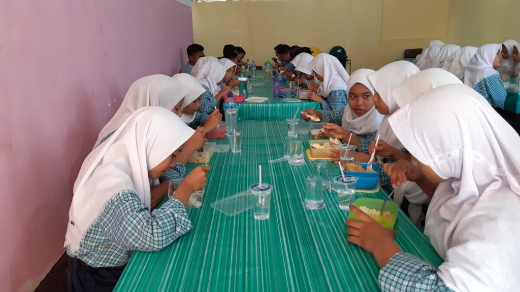 Siswa SMP Negeri 1 Labuapi, Lombok Barat, Nusa Tenggara Barat menikmati bekal sarapan mereka di hari Kamis (10/10/2019). Setiap hari mereka wajib membawa bekal yang bergizi, boleh dimasak sendiri dan boleh juga dibeli, minimal untuk sarapan.