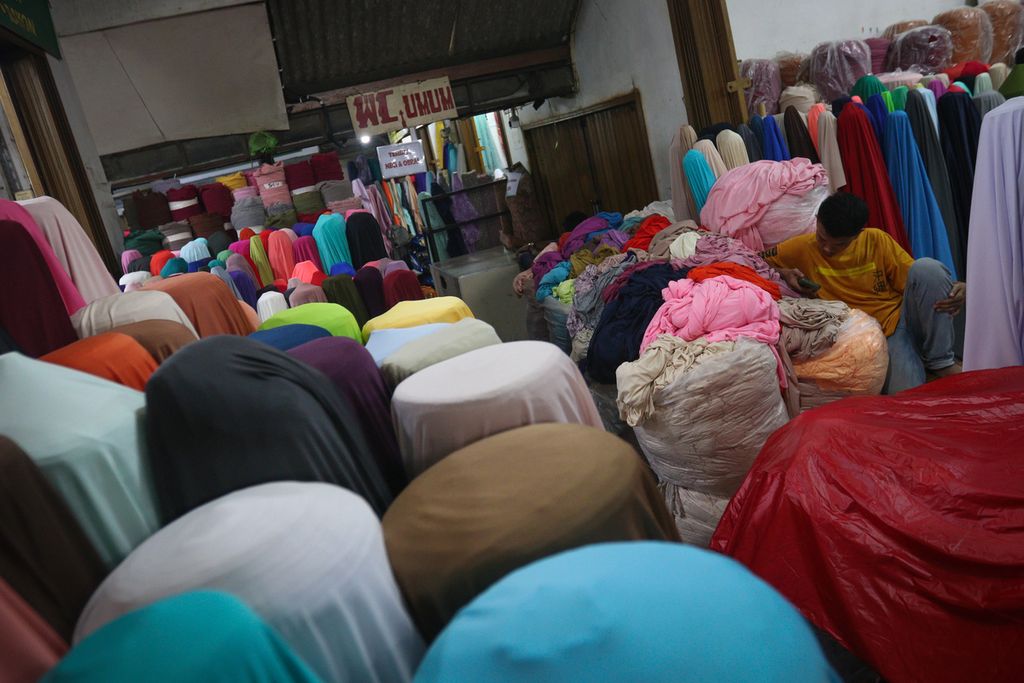 Seorang pedagang tekstil menunggu pembeli di Pasar Cipadu, Tangerang, Banten, Kamis (3/11/2022). Kawasan Cipadu dikenal sebagai sentra perdagangan tekstil di Tangerang. Di tengah lesunya permintaan, para pedagang tekstil tetap bertahan dengan berbagai cara. 