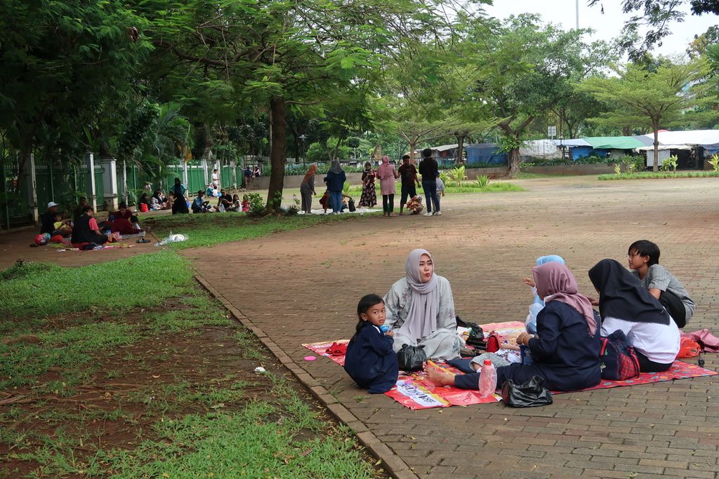 Sejumlah warga berpiknik di masa perayaan hari Lebaran H+1 di kawasan Monas, Jakarta, Selasa (3/5/2022). Meskipun sedang tutup, sejumlah warga yang memutuskan untuk menghabiskan waktu di luar rumah memilih Monas sebagai tujuan.
