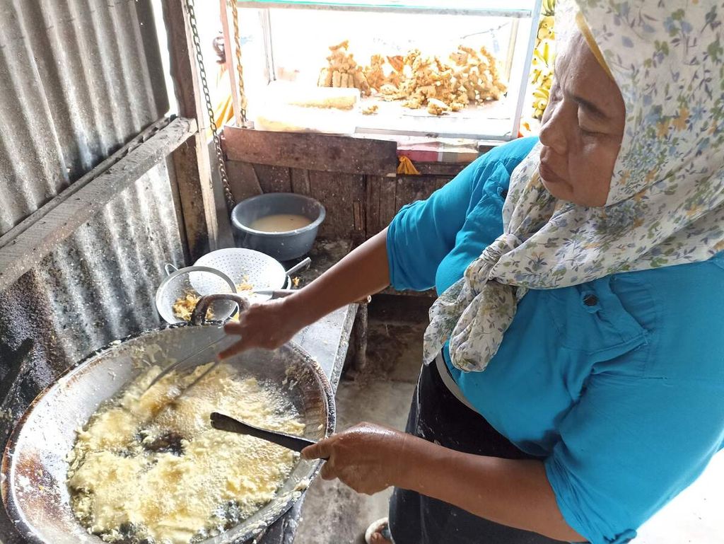Nuriati (50) menggoreng berbagai kudapan di warungnya di Medan, Sumatera Utara, Jumat (18/3/2022). Pedagang berskala usaha mikro, kecil, dan menengah terpukul akibat naiknya harga minyak goreng. 