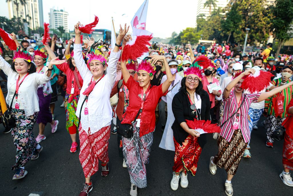 Para peserta mengikuti jalan santai sambil menari di Jalan Jenderal Sudirman, Jakarta, saat pelaksanaan hari bebas kendaraan bermotor, Minggu (19/6/2022).