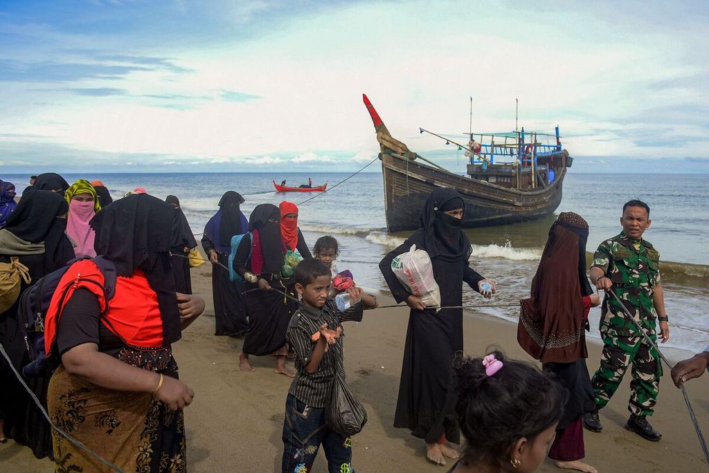 Para pengungsi Rohingya diarahkan setelah perahu mereka yang mengangkut 119 orang mendarat di pesisir Bluka Teubai, Aceh Utara, 16 November 2022, setelah bertahan selama lima pekan dalam perjalanan laut. 