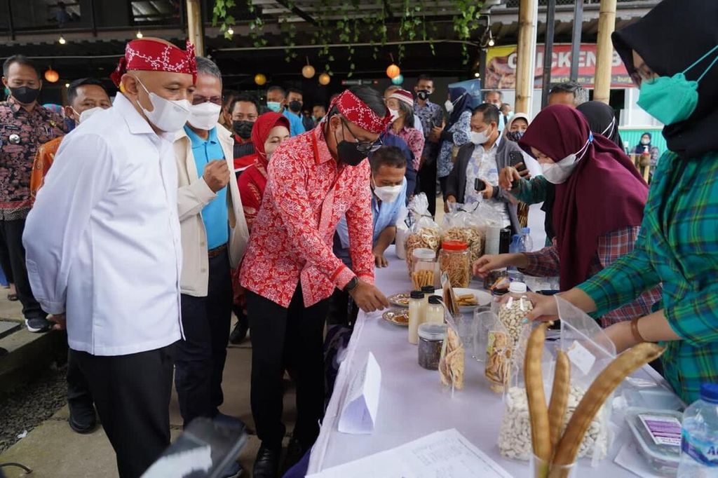 Festival Olahan Pangan Lokal Berbasis Kacang Koro digelar di Kota Bogor, Jawa Barat, Jumat (1/4/2022). Menteri Koperasi dan UKM Teten Masduki (kiri) sedang memperhatikan Wali Kota Bogor Bima Arya (ketiga dari kiri) mencicipi makanan yang terbuat dari kacang koro.
