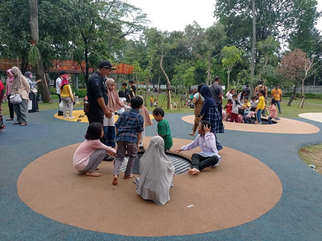 Petugas keamanan mengawasi anak-anak yang bermain trampolin di Tebet Eco Park, Jakarta Selatan (5/5/2022). Arena permaian anak menjadi salah satu daya tarik taman ini.