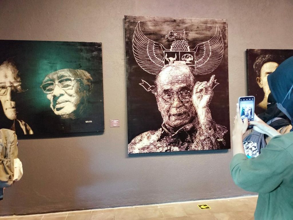 Sejumlah pengunjung melihat dan memotret beberapa lukisan yang ditampillkan dalam pameran seni rupa bertajuk Mata Air Bangsa: Persembahan untuk Gus Dur dan Buya Syafii Maarif di OHD Museum, Magelang, Sabtu (30/7/2022).