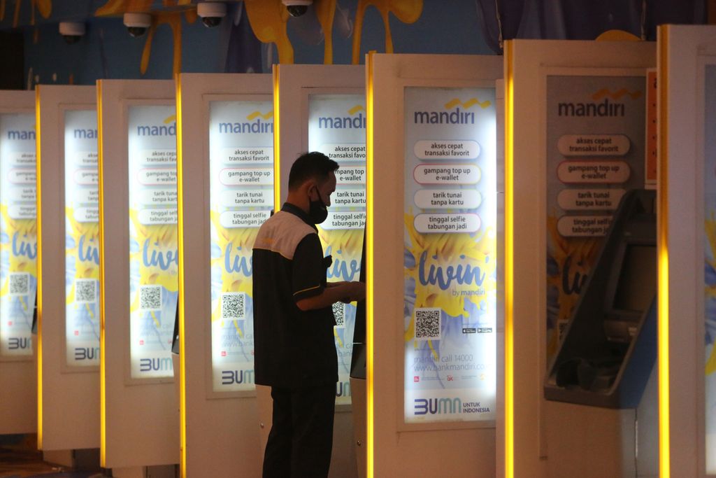 Nasabah menarik uang melalui mesin anjungan tunai mandiri di kantor cabang PT Bank Mandiri (Persero) Tbk, Jakarta, Senin (25/4/2022). 