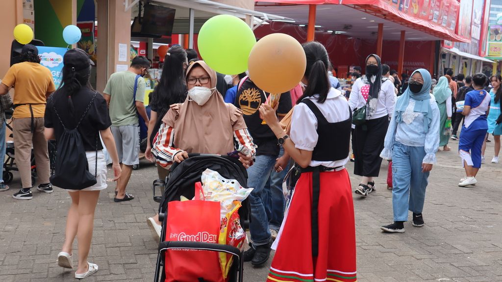 Seorang <i>sales promotion girl</i> (SPG) yang memegang balon dan berpakaian unik tengah berusaha memikat hati pengunjung Jakarta Fair Kemayoran, Jakarta Pusat, Sabtu (18/6/2022).