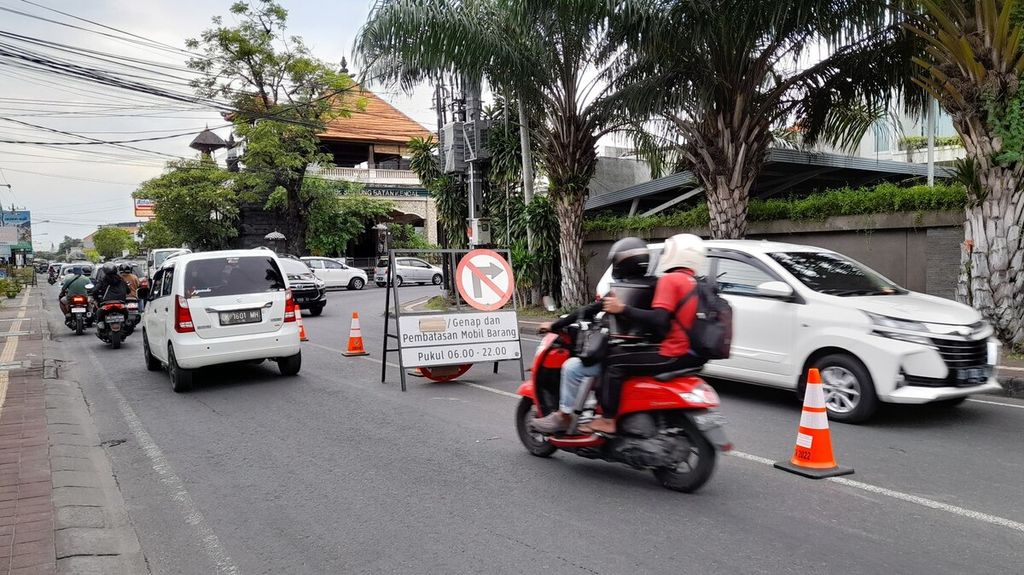 Plang pengumuman penerapan sistem ganjil-genap dan pembatasan mobil barang dipasang di tengah Jalan Suwung Batan Kendal, Denpasar Selatan, Bali, Jumat (11/11/2022).