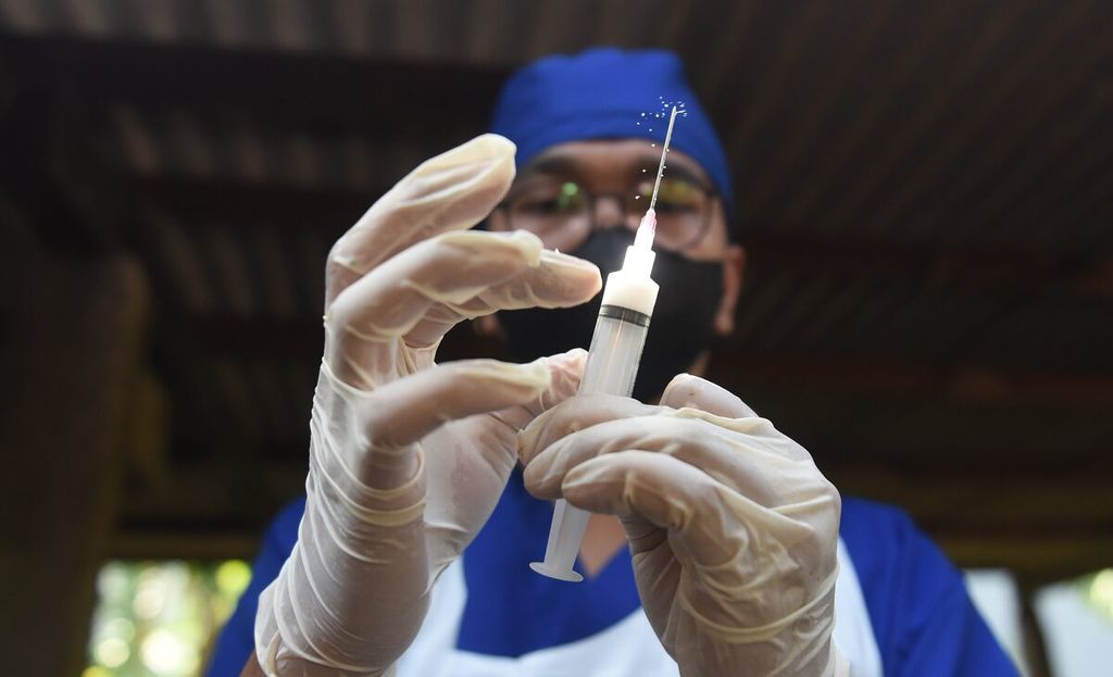 Petugas menyiapkan vaksin penyakit kuku dan mulut (PMK) ke sapi perah dengan suntikan manual di Kelurahan Bendul Merisi, Kecamatan Wonocolo, Kota Surabaya, Jawa Timur, Sabtu (25/6/2022). 