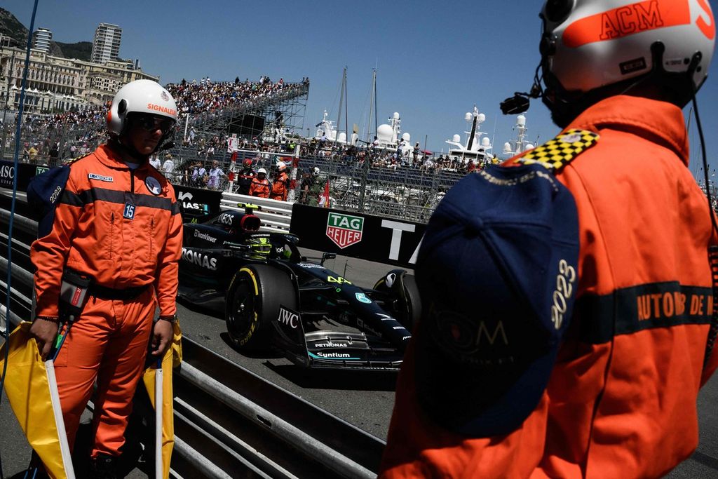 Marshal balapan berdiri di sisi lintasan saat pebalap Mercedes Lewis Hamilton melintas pada sesi latihan pertama Grand Prix Formula 1 Monako, Jumat (26/5/2023).