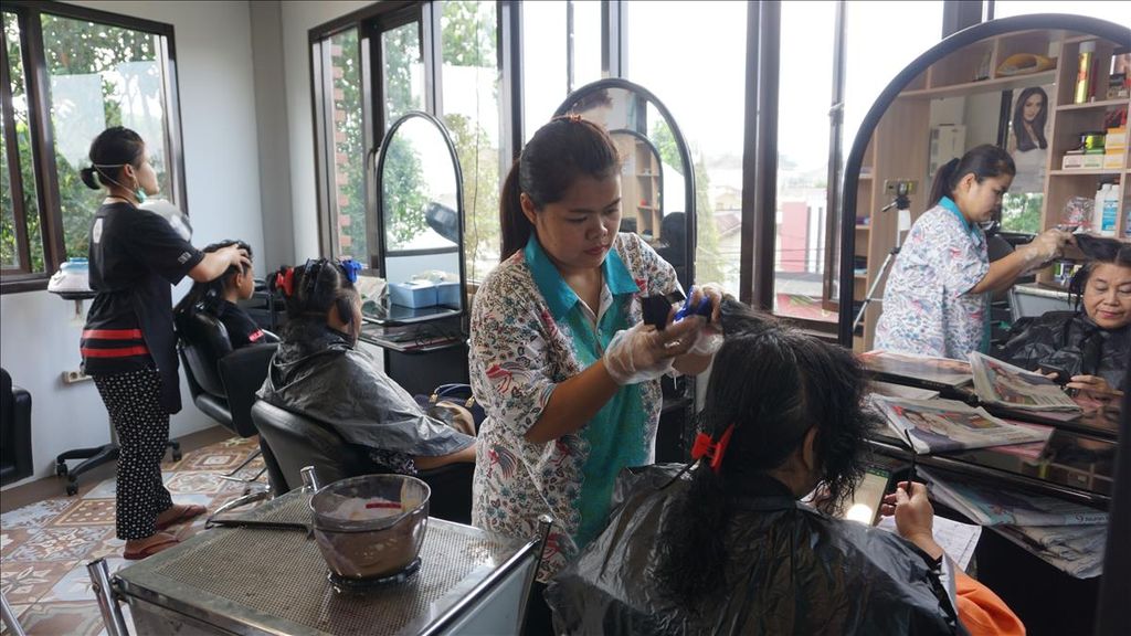 Rita Sari, insan tunarungu, sedang menyemir rambut pelanggannya di Salon Mute.Area, Wonosobo, Jawa Tengah, Rabu (29/5/2019). Mute.Area atau kawasan hening merupakan tempat berkarya bagi para penyandang tunarungu. Selain salon di lantai dua, ada pula usaha kafe di lantai satu.
