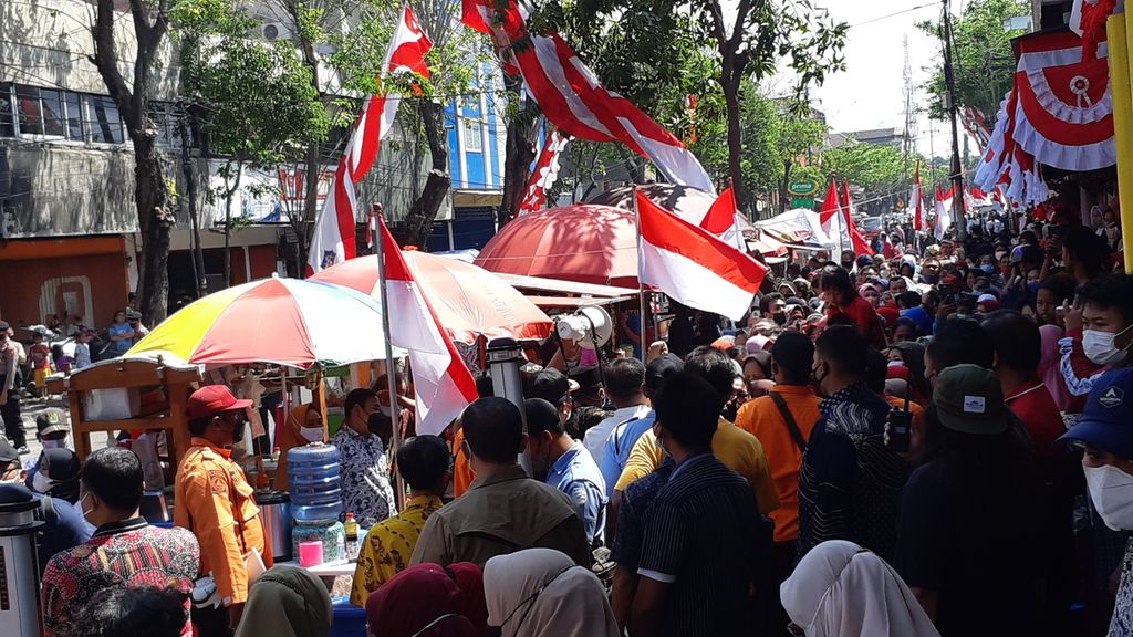 Ratusan warga berjubel menunggu kedatangan Presiden Joko Widodo di Pasar Pucang Anom, Surabaya, Minggu (21/8/2022).