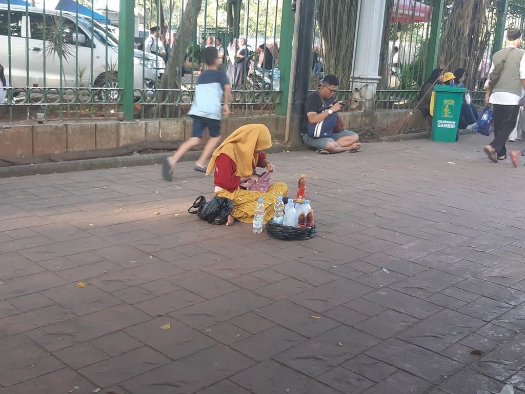 Seorang pedagang minuman tengah menjajakan dagangannya di sekitar Monas, Jakarta Pusat, Sabtu (18/3/2023).