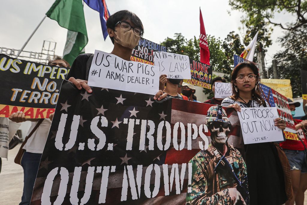 Demonstran berunjuk rasa di depan markas militer Camp Aguinaldo di Quezon City, Filipina, Selasa (11/4/2023). Mereka memprotes upacara pembukaan bendera latihan militer bersama bertajuk Balikatan.